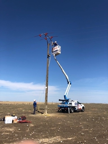 Electricista realizando trabajos en altura con una grúa.