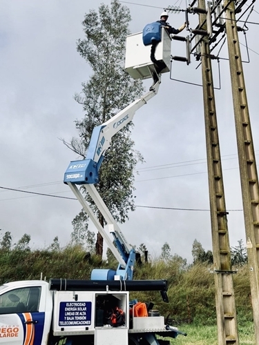 Electricista realizando una instalación en un poste de tendido eléctrico.