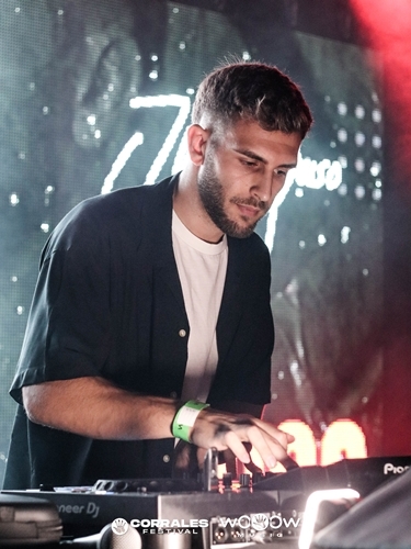 DJ tocando música en un evento, fotografía profesional de ocio nocturno.