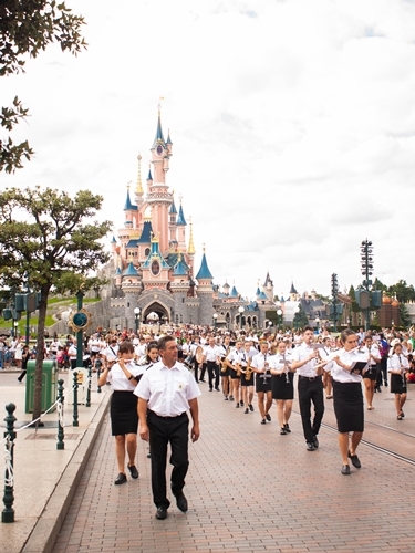 Desfile de personas en un parque temático.