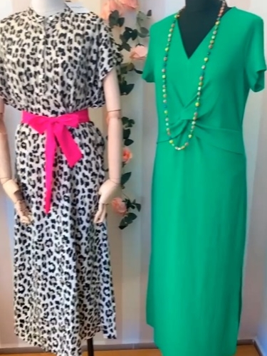 Maniquí con un elegante vestido verde y cinturón animal print.
